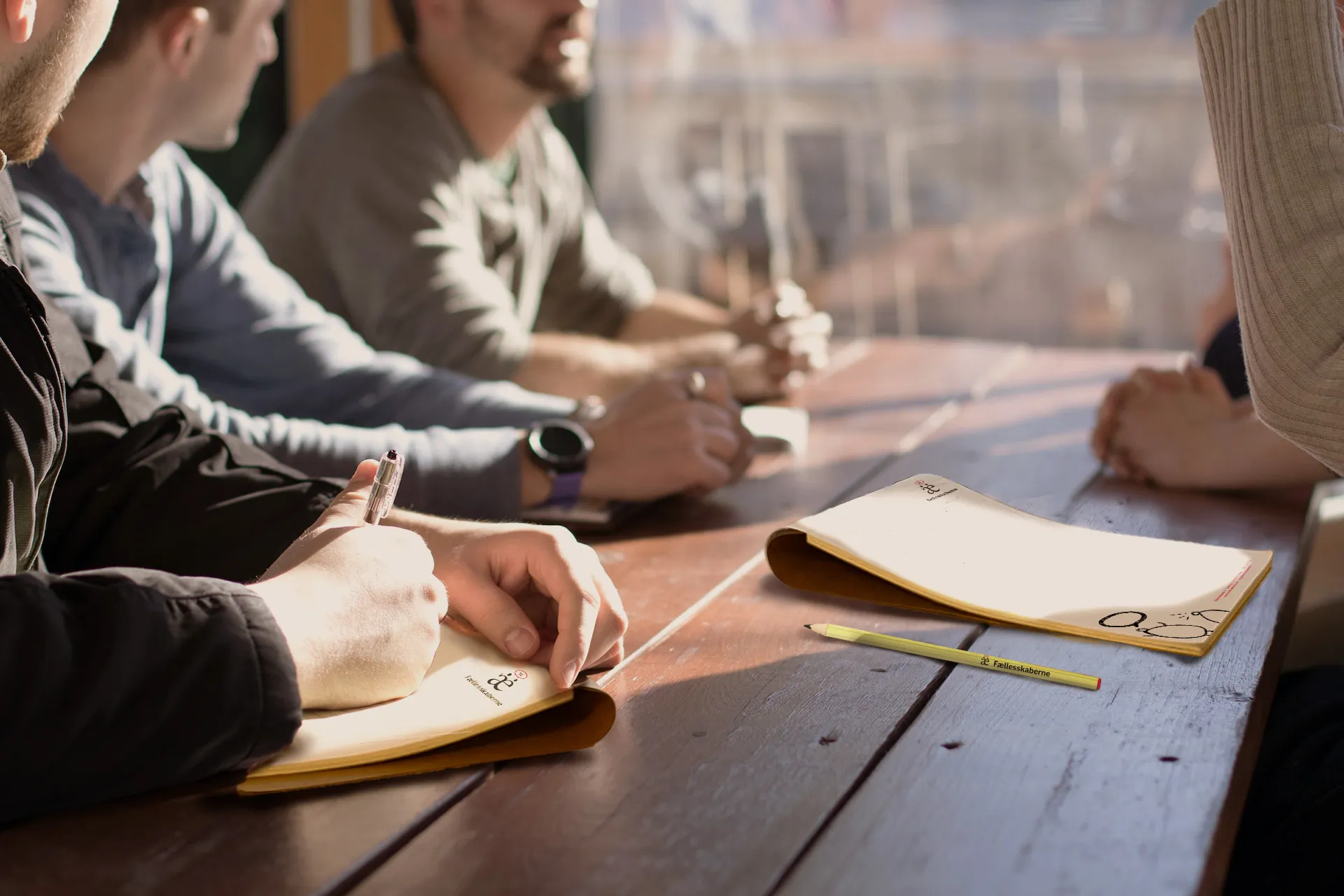 Workers talking together while using a branded notebook